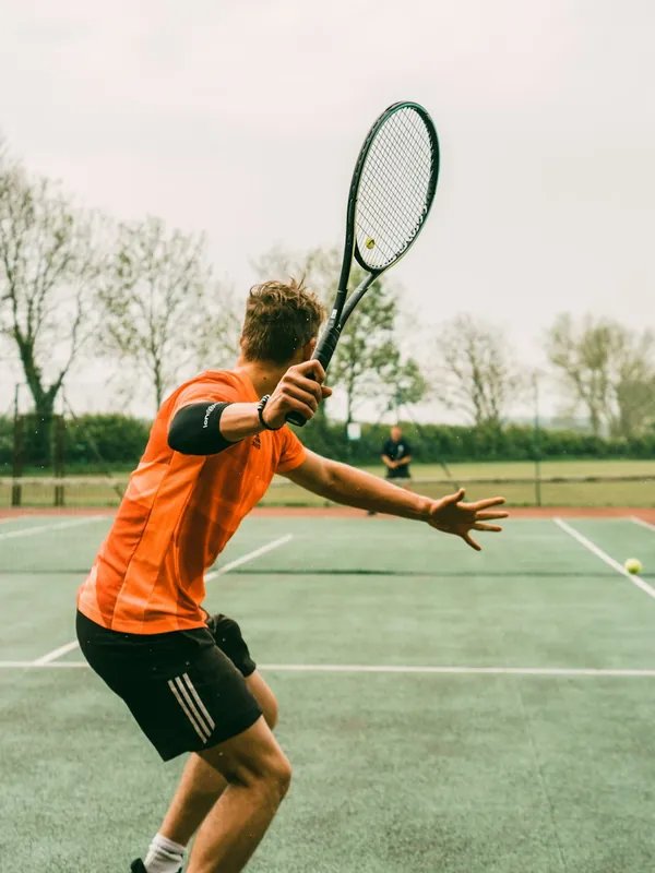 A tennis player stretching for a forehand
